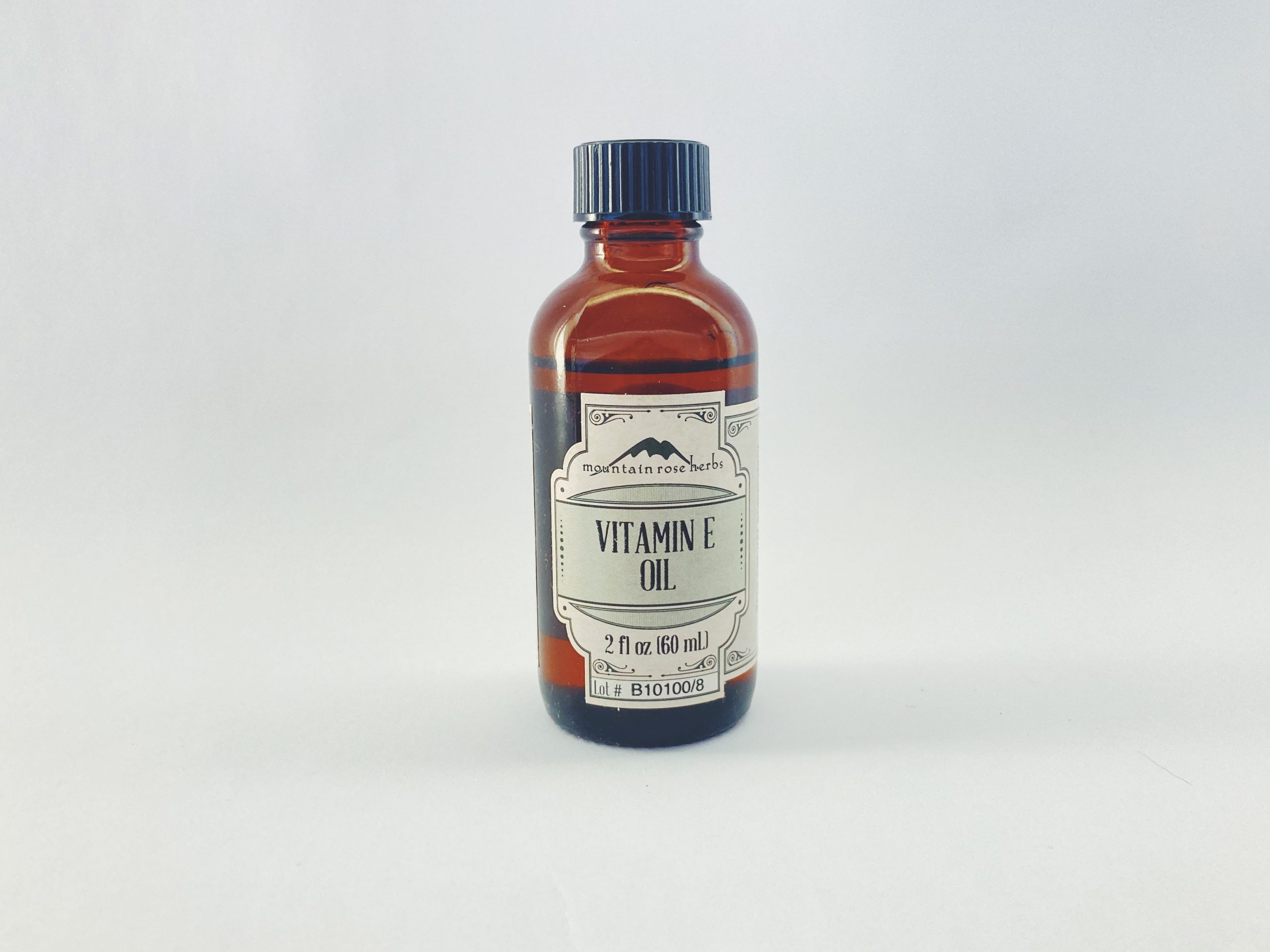 Small bottle of vitamin E oil on a white background.