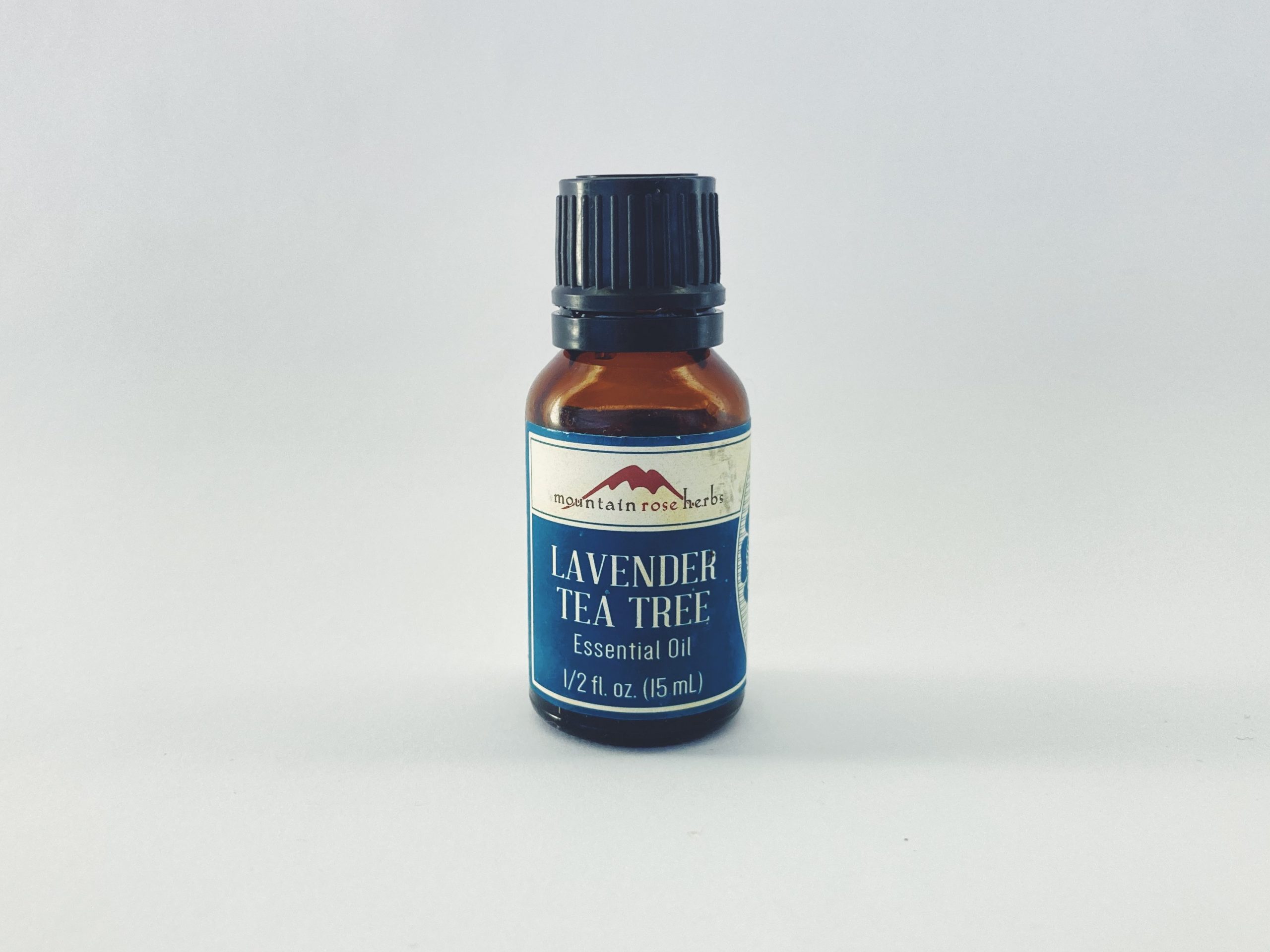 Small bottle of lavender tea tree essential oil on a white background.