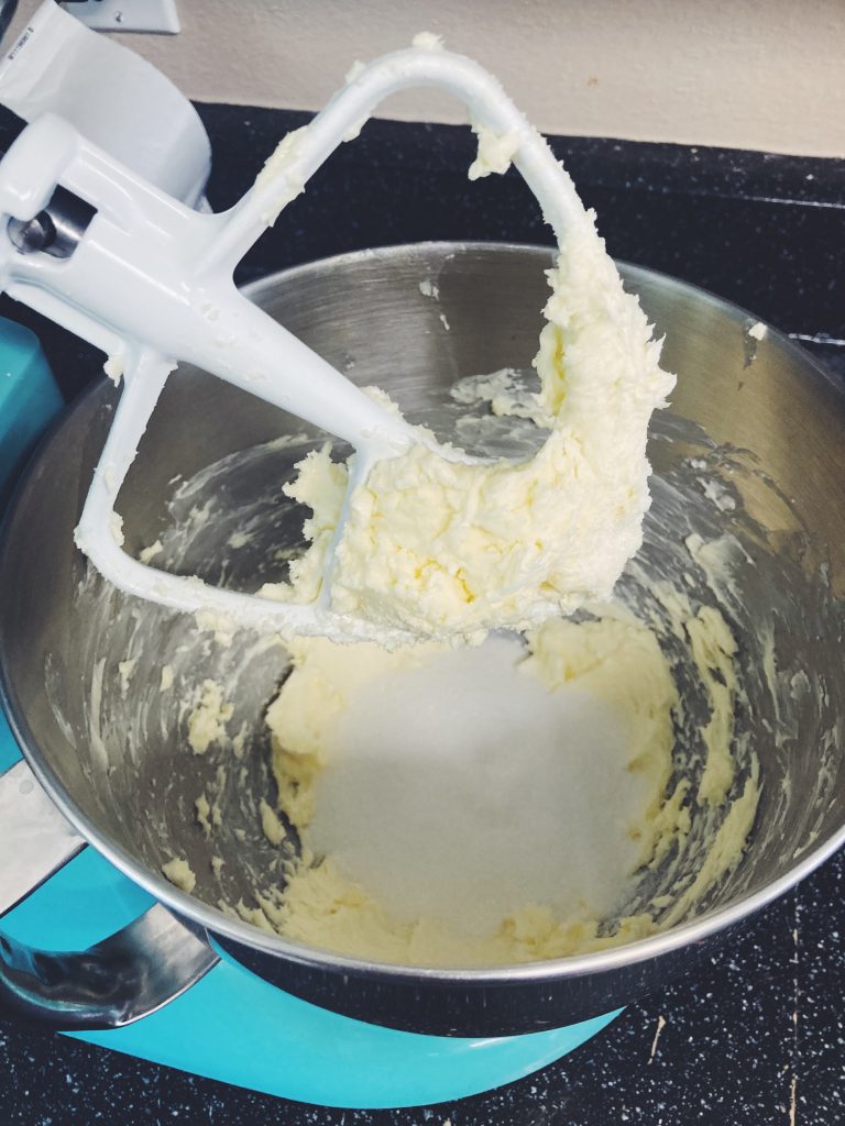 Butter and sugar being creamed together in a stand mixer.